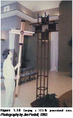 Подпись: Figure 5.18 Carrying a 12.5-lb processional cross. Photography by Jim Postell, 1993. 